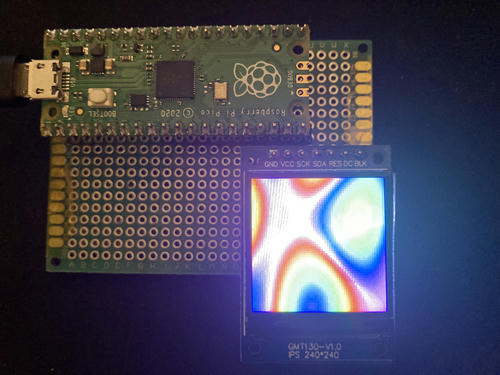 Pico dev board plugged in via USB, with a small LCD displaying a rainbow pattern