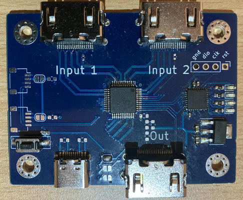 Picture of the board - with two HDMI ports labelled Input 1 and 2, and a third labelled Out.