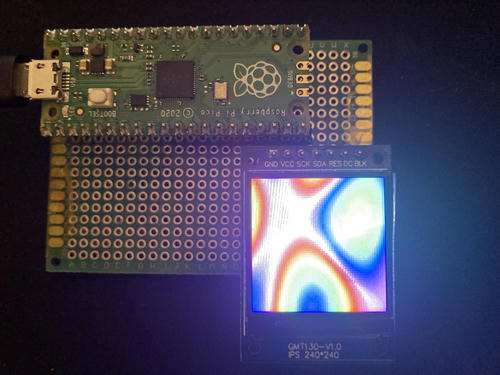 Pico dev board plugged in via USB, with a small LCD displaying a rainbow pattern